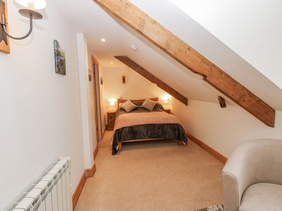 A bedroom with a bed and nightstands at 1 Mill Cottage (known as Old Mill 1) Askrigg near West Burton