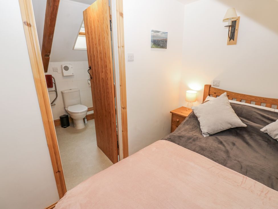 A bedroom with a bed and an adjoining bathroom at 1 Mill Cottage (known as Old Mill 1) Askrigg near West Burton