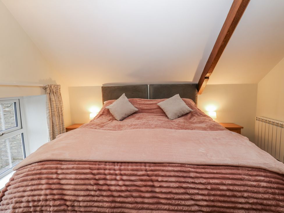A bedroom with a bed and bedside tables at 1 Mill Cottage near West Burton