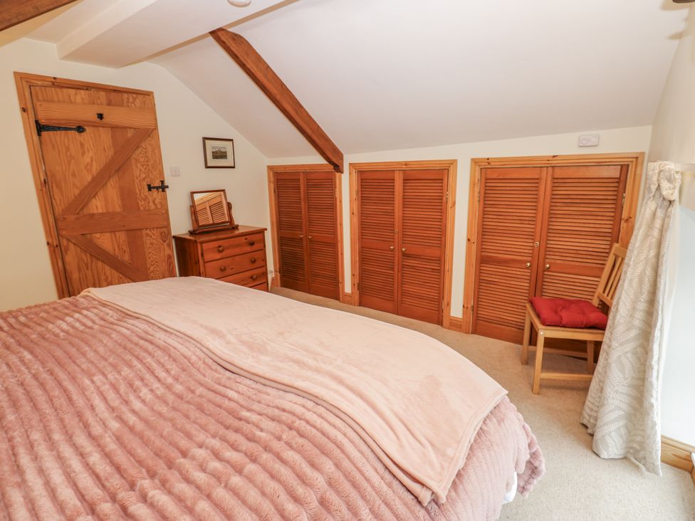 A bedroom with a bed and wooden furniture at 1 Mill Cottage (known as Old Mill 1) Askrigg near West Burton