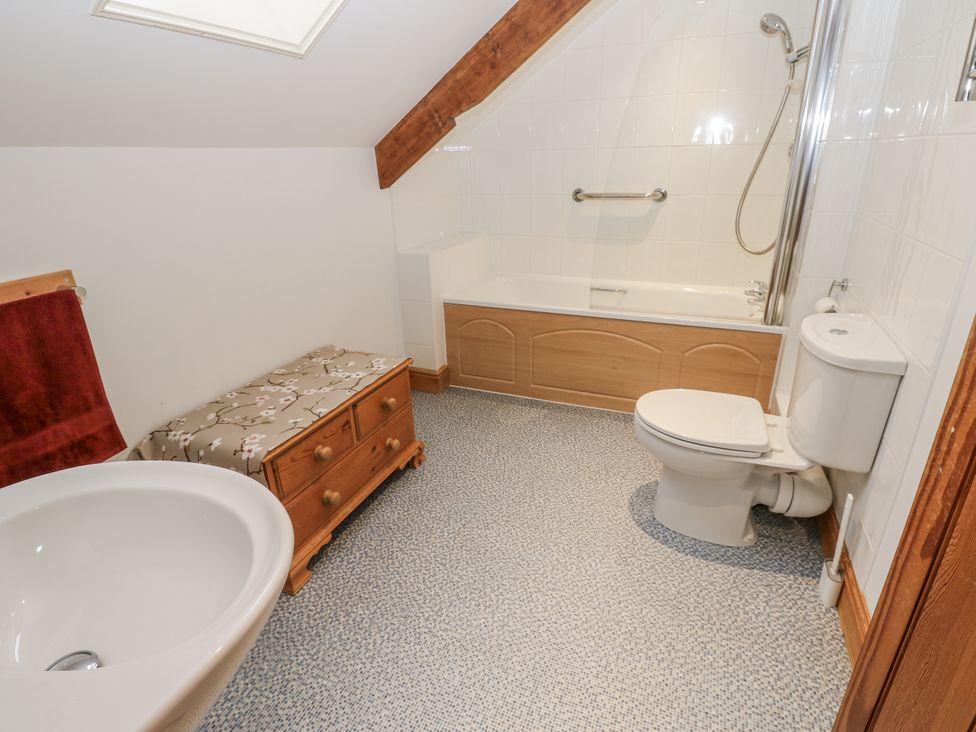 A bathroom with a sink, toilet, bathtub, and shower at 1 Mill Cottage (known as Old Mill 1) Askrigg near West Burton