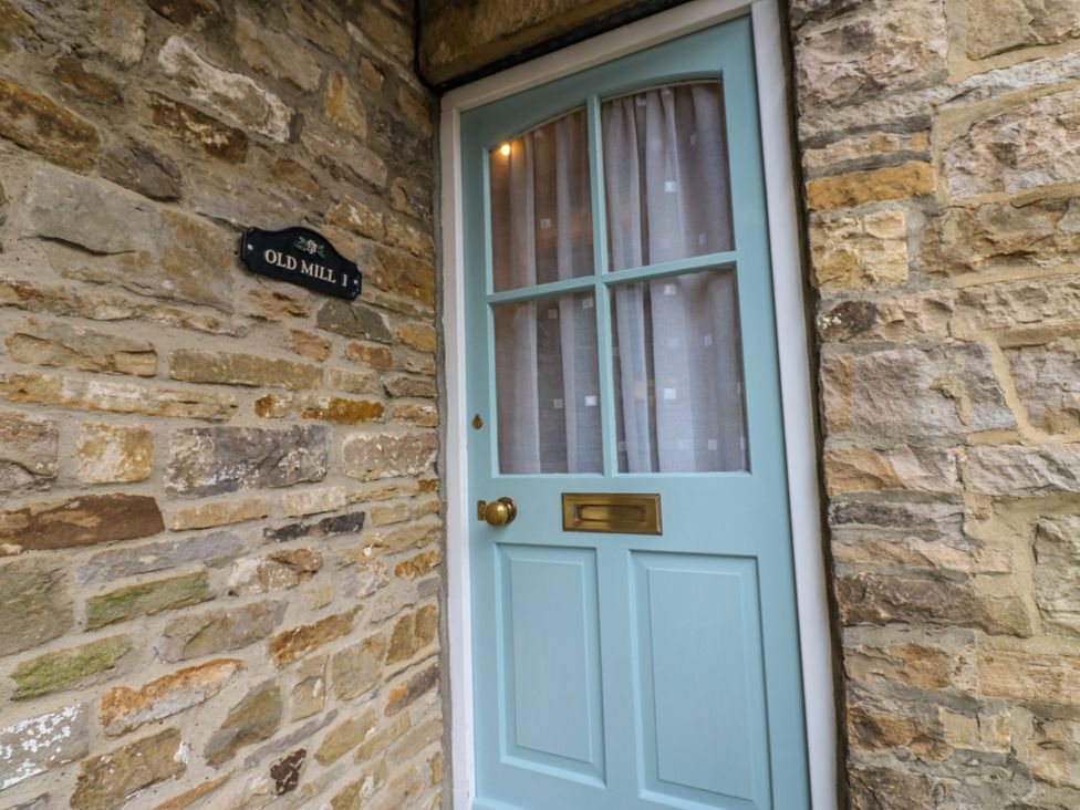 A door with a window and stone wall at 1 Mill Cottage (known as Old Mill 1) Askrigg near West Burton