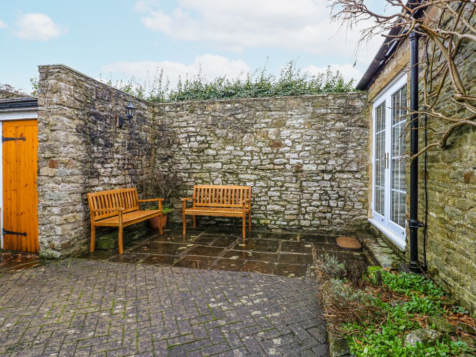 An outdoor area with benches and stone wall at 1 Mill Cottage (known as Old Mill 1) Askrigg near West Burton