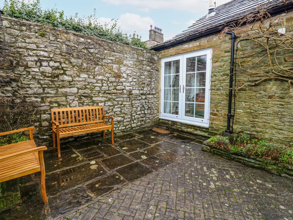 A garden with benches and a stone wall at 1 Mill Cottage (known as Old Mill 1) Askrigg near West Burton