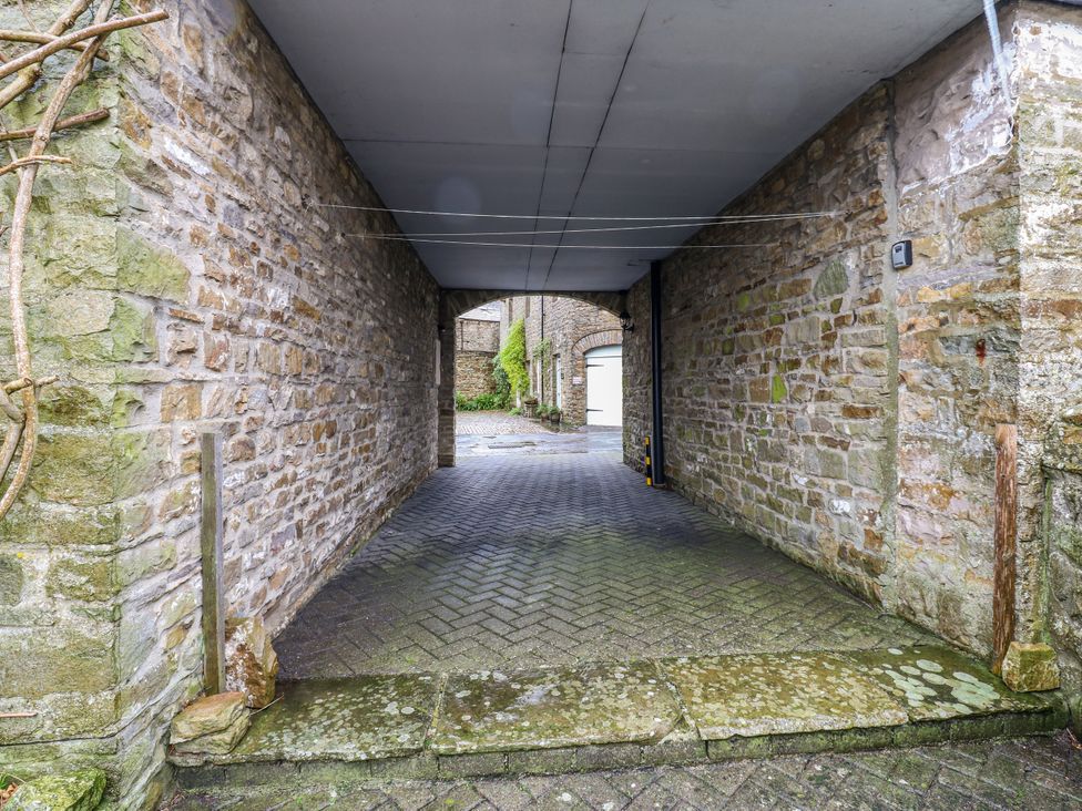 A stone pathway beneath a roof with stone walls and ivy at 1 Mill Cottage (known as Old Mill 1) Askrigg near West Burton