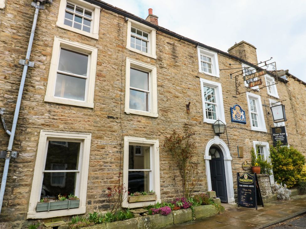 A stone building with windows and a sign at The Kings Arms Askrigg near West Burton