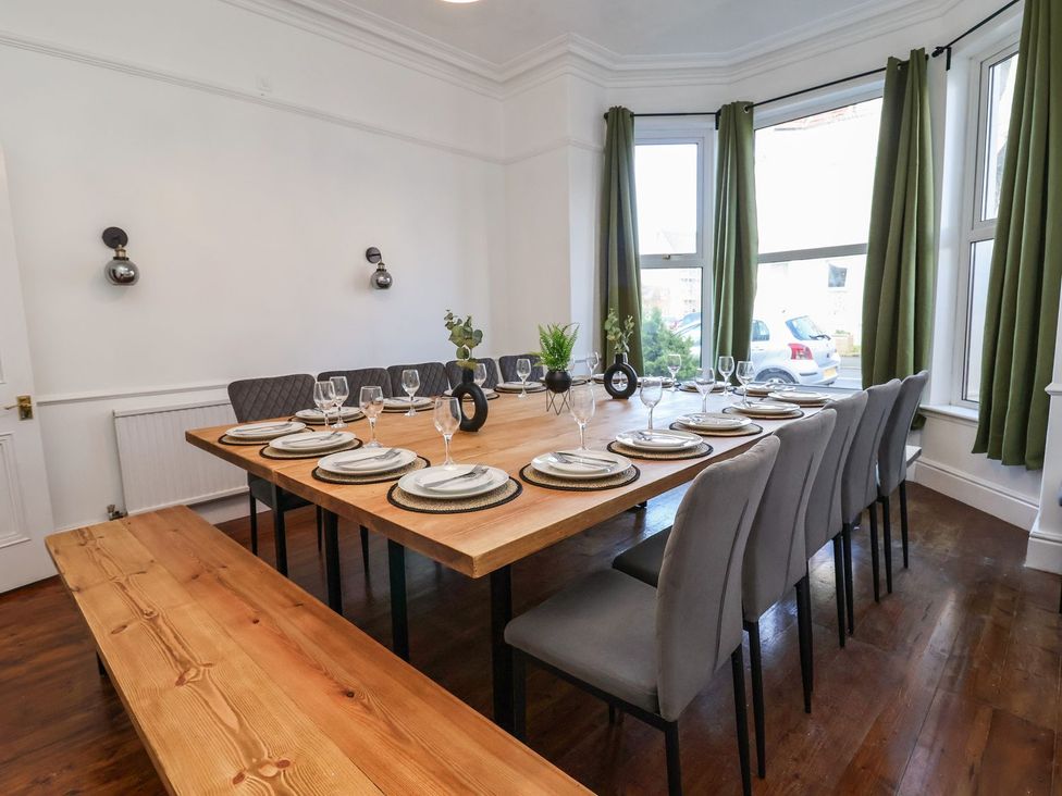 A dining room with a large table set for dinner at Mariners Lee
