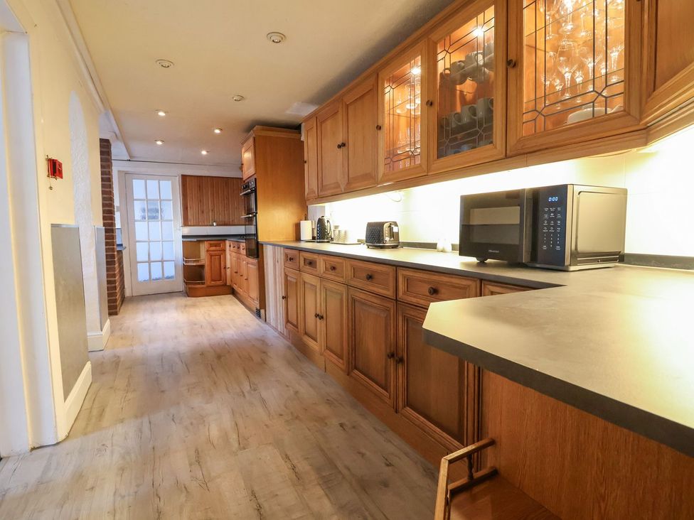 A kitchen with wooden cabinets and appliances at Mariners Lee