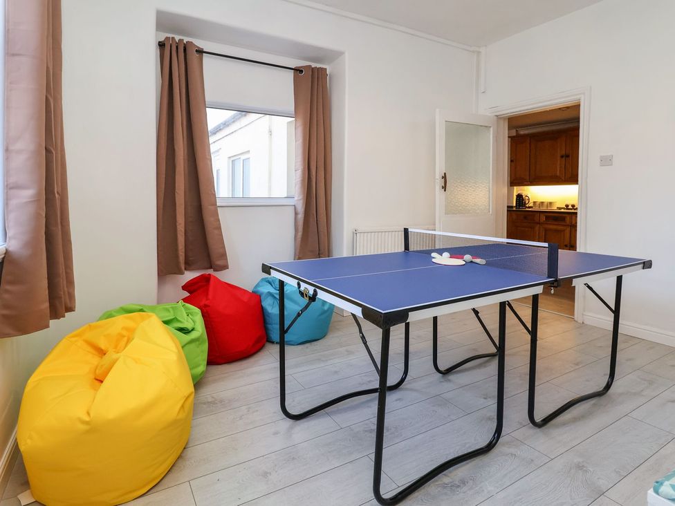 A game room with a ping pong table and colorful bean bag chairs at Mariners Lee