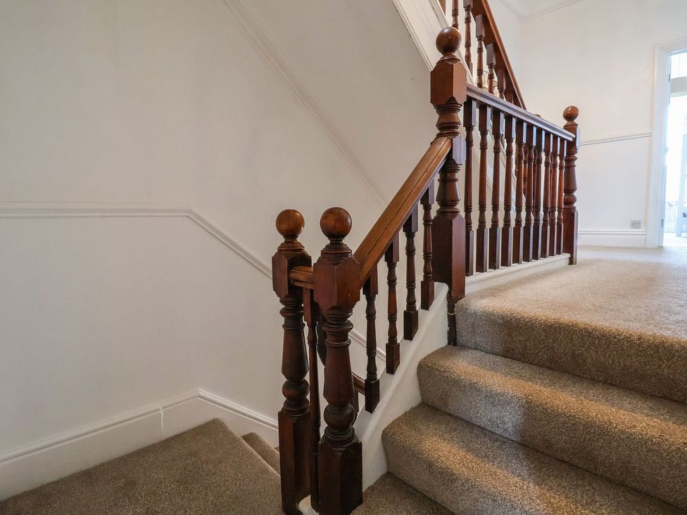 A staircase with wooden railing and carpet at Mariners Lee