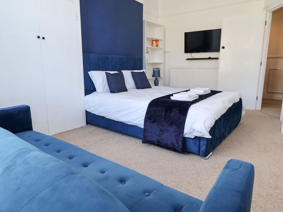 A bedroom with a bed and a sofa at Mariners Lee