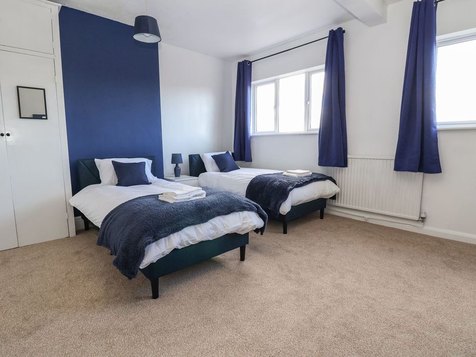 A bedroom with two single beds and a wardrobe at Mariners Lee