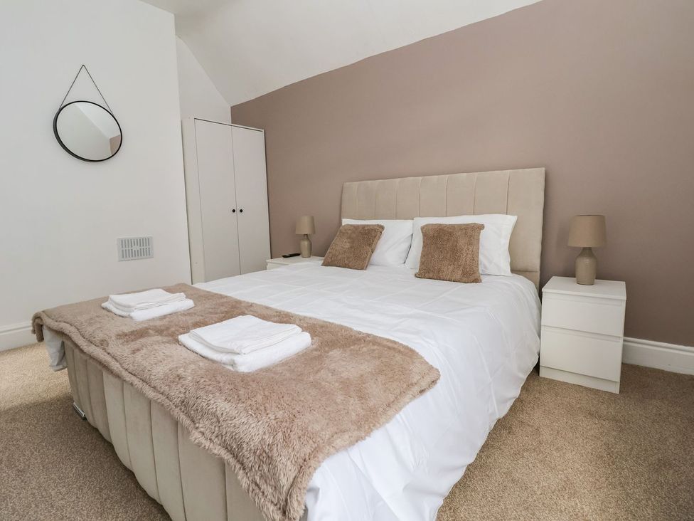 A bedroom with a bed and bedside tables at Mariners Lee