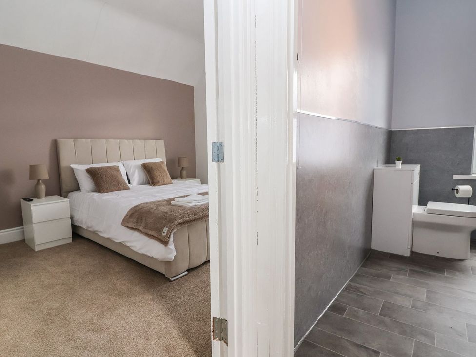 A bedroom with a bed and an adjoining bathroom at Mariners Lee