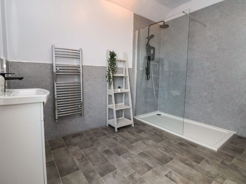 A bathroom with a shower, sink, and towel rail at Mariners Lee