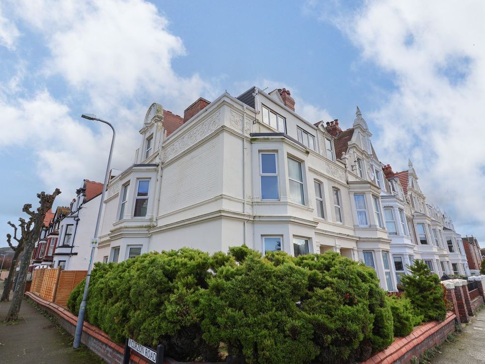 An exterior view of a building with windows and bushes at Mariners Lee