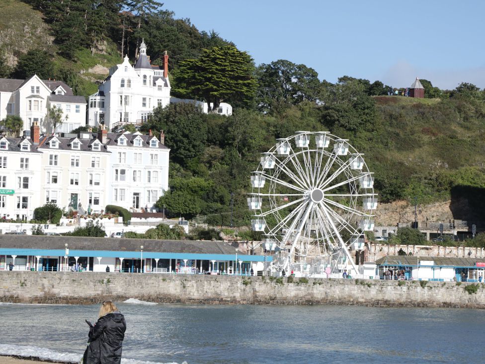 A ferris wheel by the beach with houses in the background at Mariners Lee in Llandudno