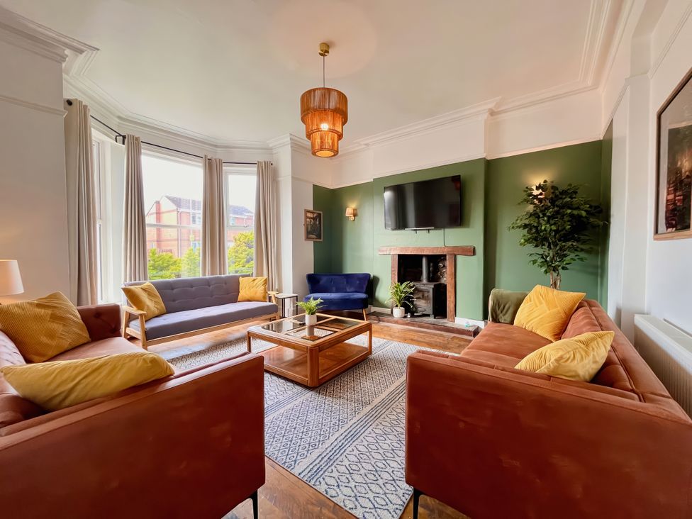 A living room with sofas and a television at Clarence House in Llandudno