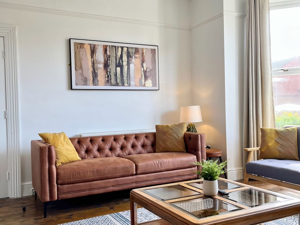 A living room with a sofa and a table at Clarence House in Llandudno