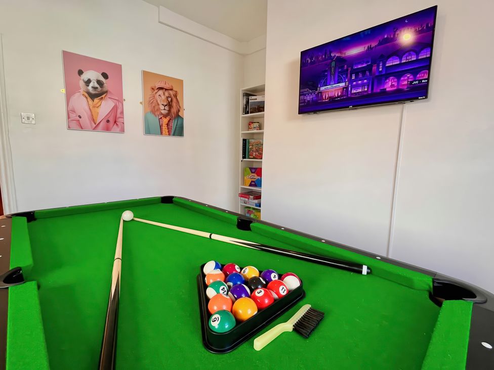 A game room with a pool table and television at Clarence House in Llandudno