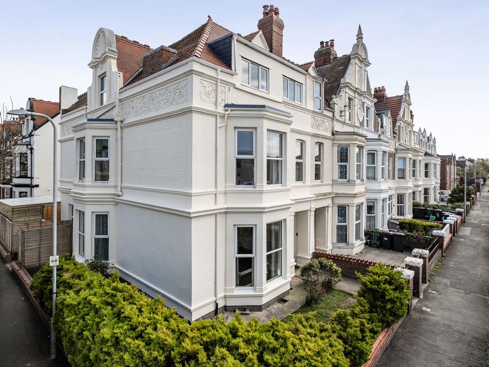 A building with multiple windows and bushes in Llandudno at Clarence House