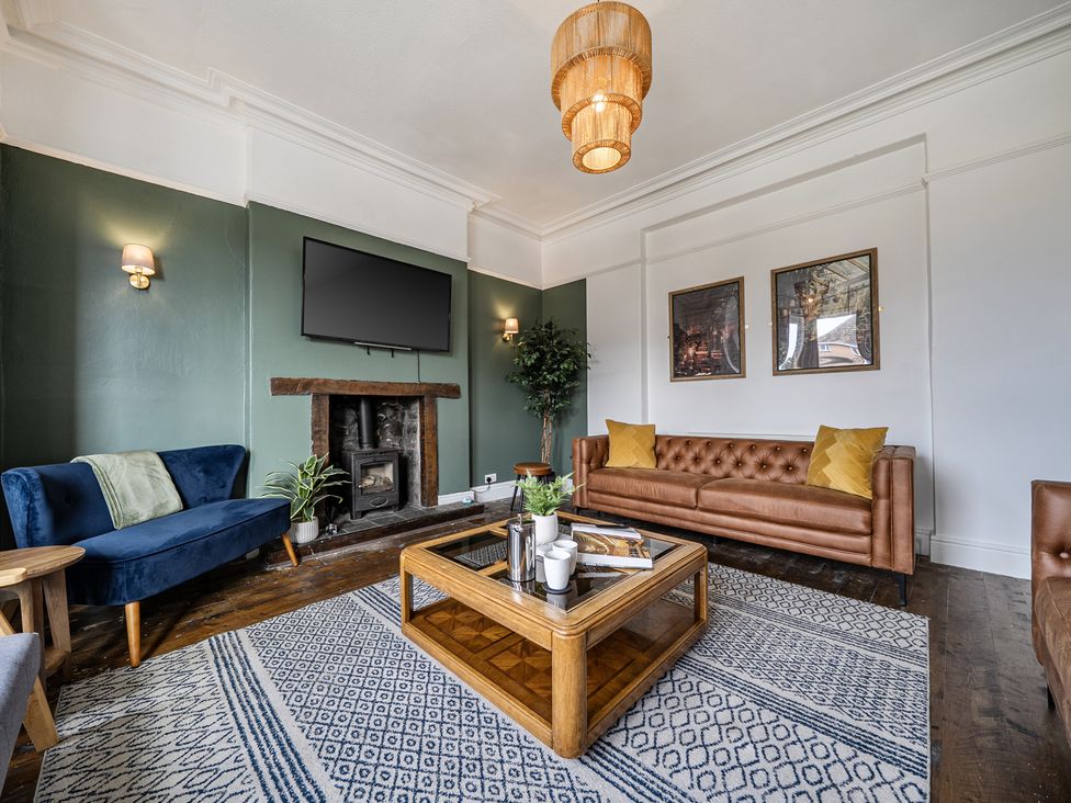 A living room with a television and coffee table at Clarence House in Llandudno