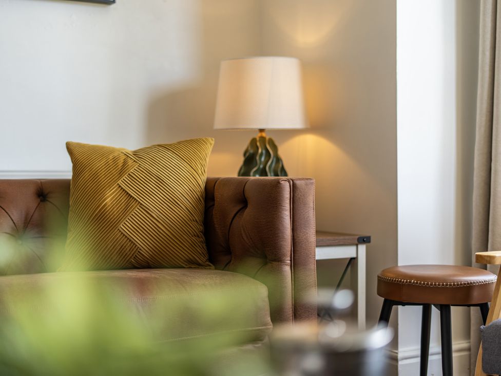 A living room with a couch and lamp at Clarence House in Llandudno
