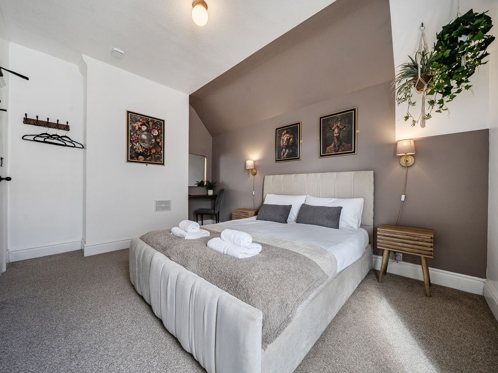 A bedroom with a bed and wall art at Clarence House Llandudno