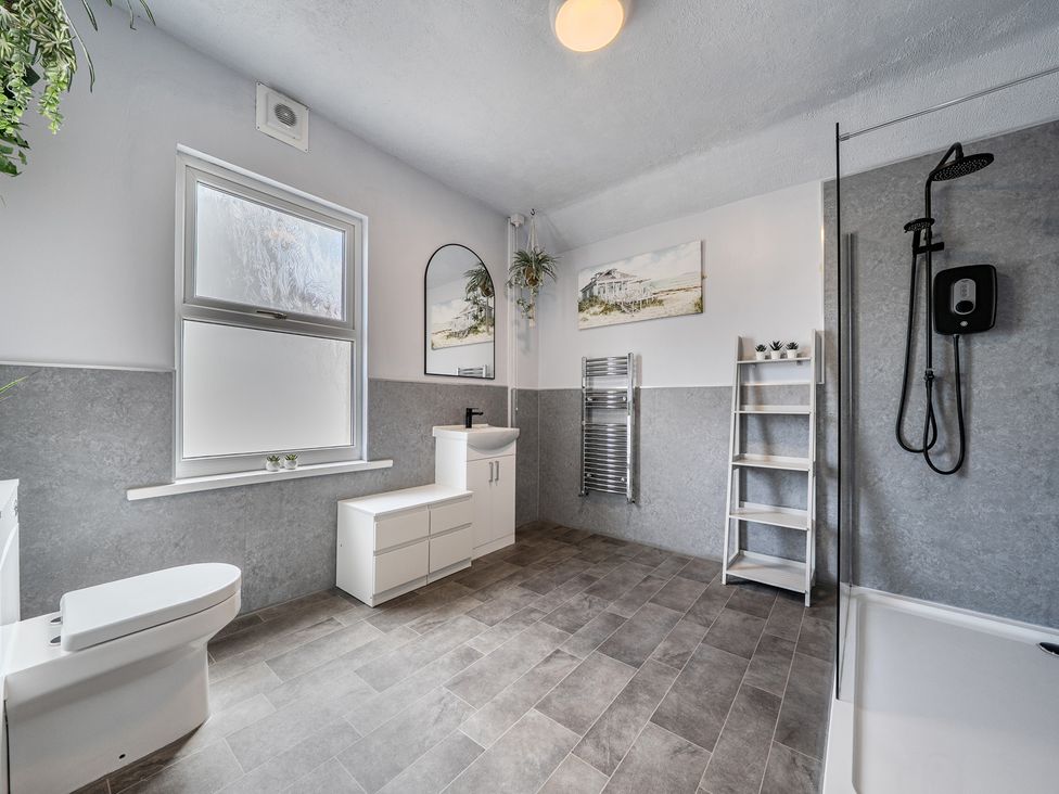 A bathroom with a toilet, sink and shower at Clarence House in Llandudno