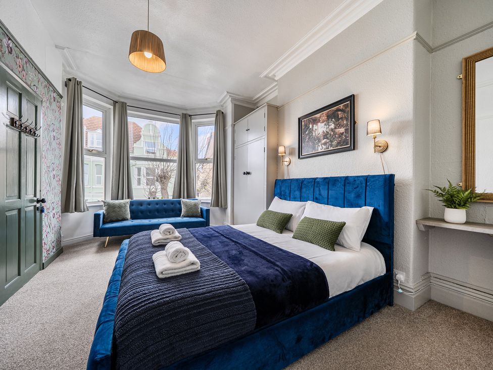 A bedroom with a bed and couch at Clarence House in Llandudno