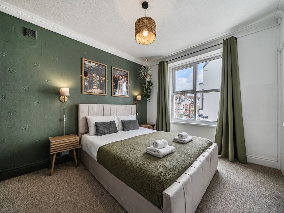 A bedroom with a double bed and nightstand at Clarence House in Llandudno
