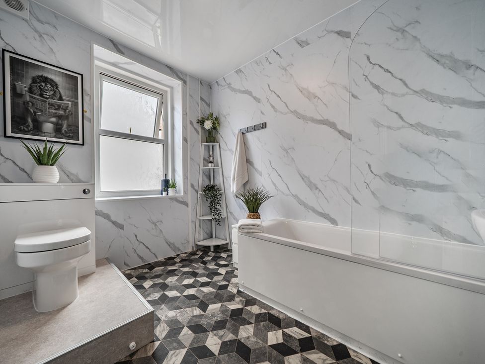 A bathroom with a bathtub and toilet at Clarence House in Llandudno
