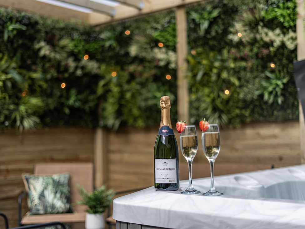 An outdoor space with a bottle of sparkling wine and glasses at Clarence House in Llandudno