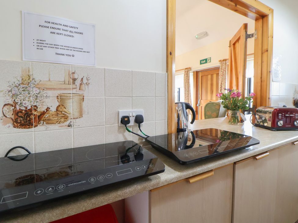 A kitchen with induction cooktops and a kettle at Clwyd Special Riding Centre