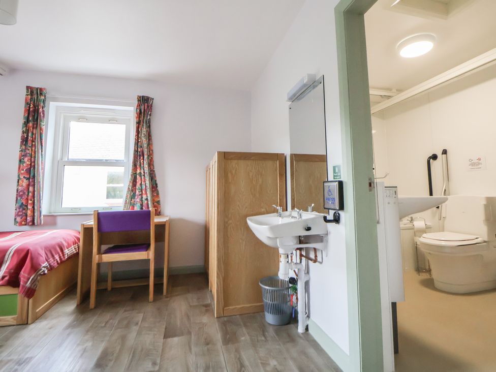 A bedroom with a bed and a desk at Clwyd Special Riding Centre