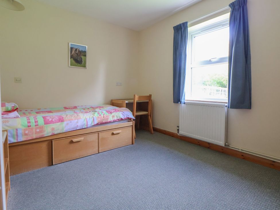 A bedroom with a bed, desk, and chair at Clwyd Special Riding Centre