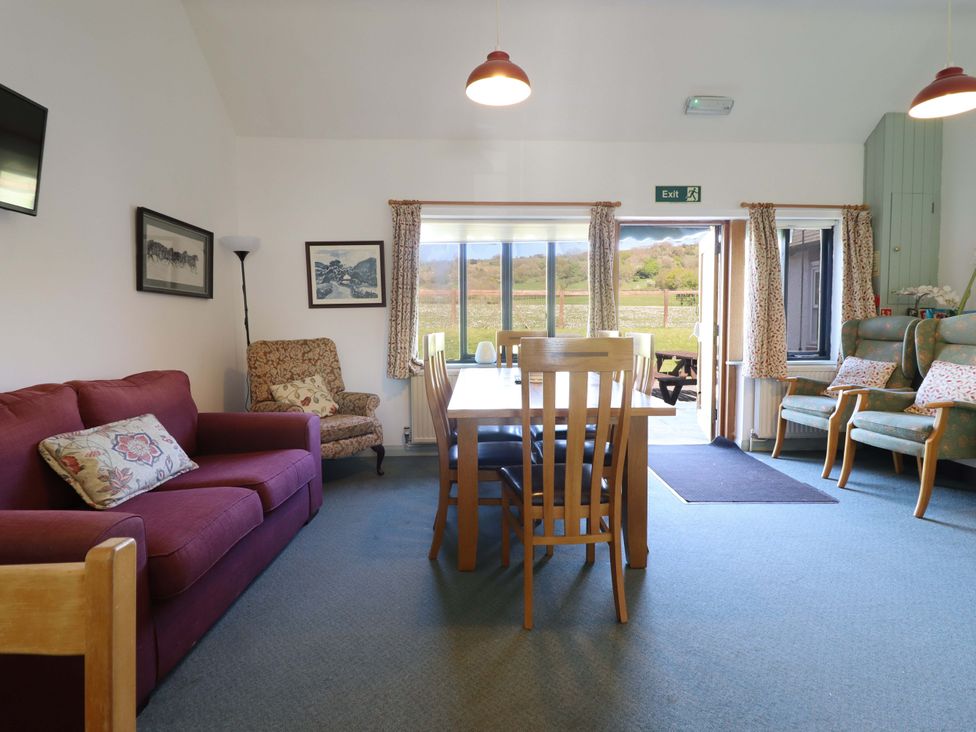 A dining room with a table and chairs at Clwyd Special Riding Centre in Llanfynydd