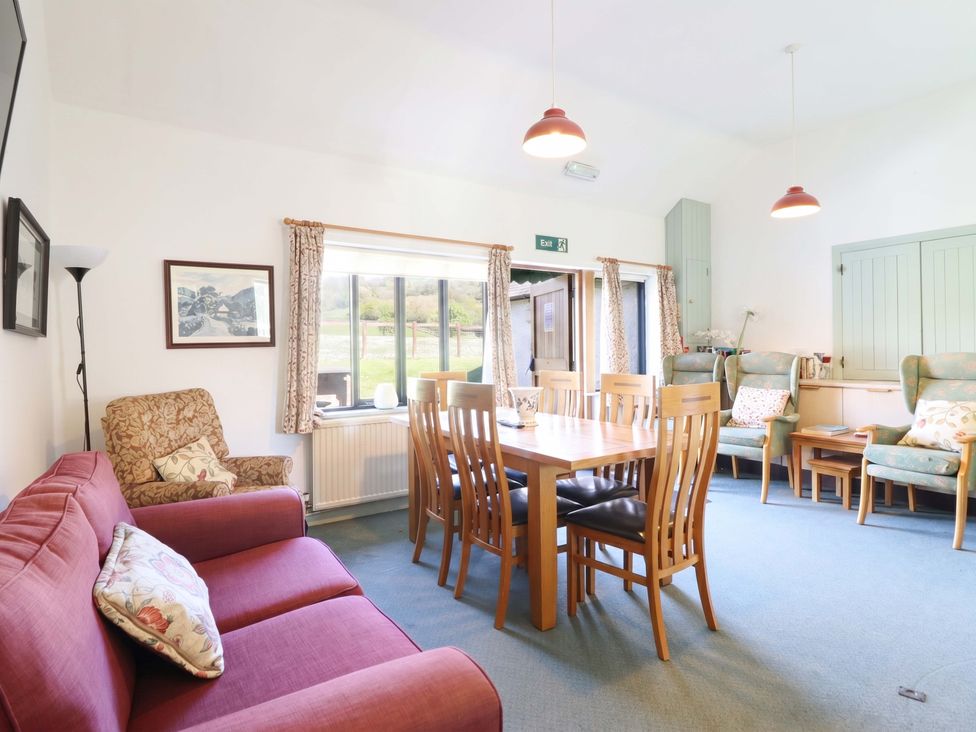 A dining room with a table and chairs at Clwyd Special Riding Centre Llanfynydd