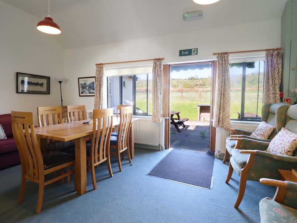 A dining room with a table and chairs at Clwyd Special Riding Centre Llanfynydd