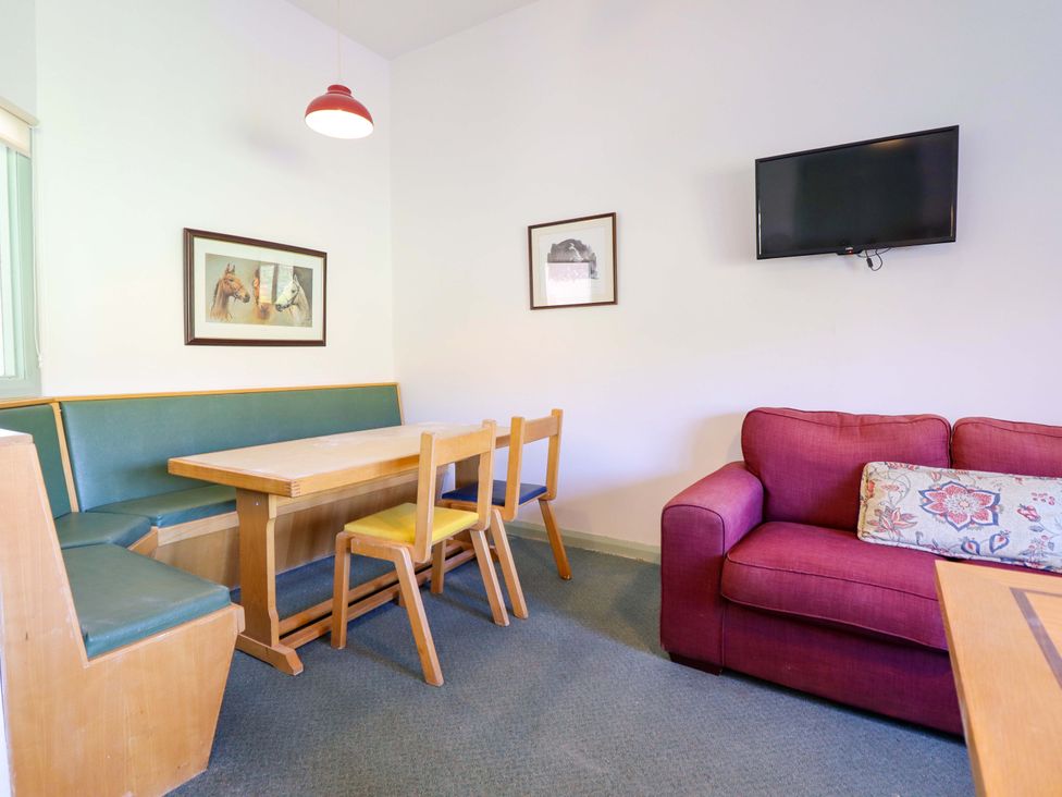 A dining area with a table and chairs at Clwyd Special Riding Centre in Llanfynydd