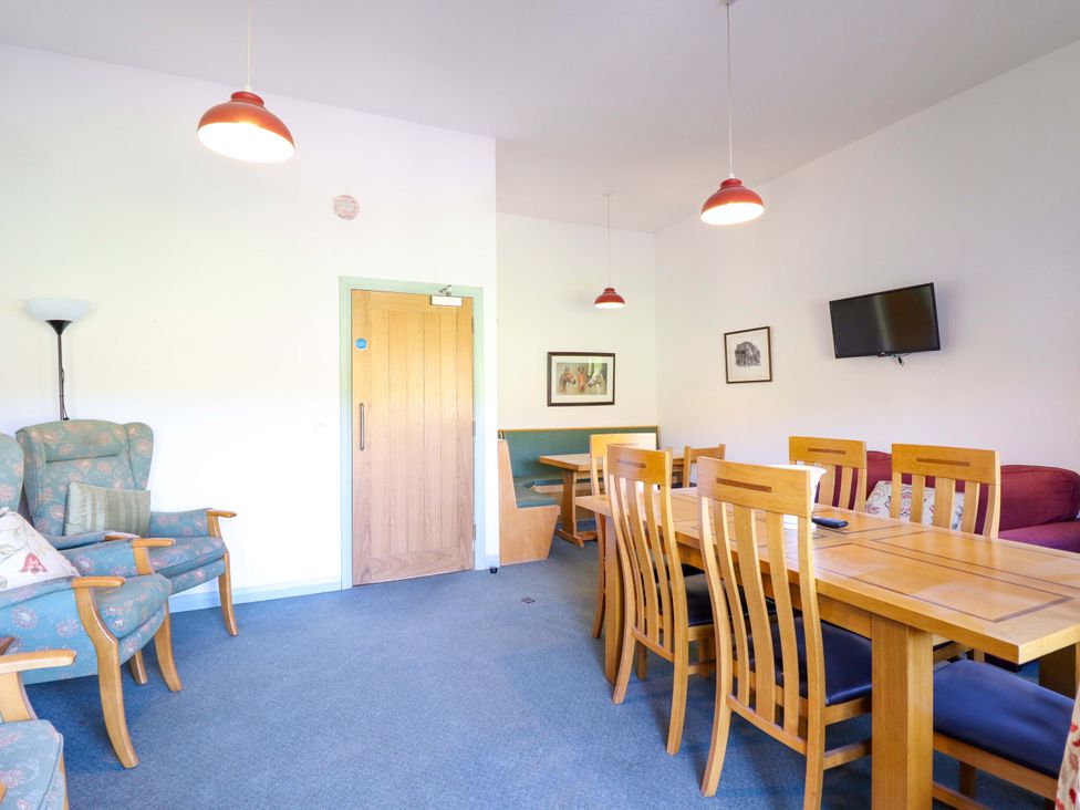 A dining room with a table and chairs at Clwyd Special Riding Centre in Llanfynydd