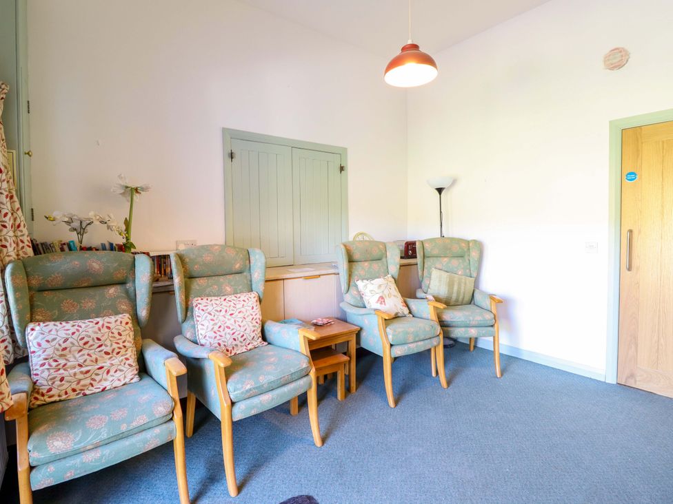 A sitting room with chairs and a small table at Clwyd Special Riding Centre in Llanfynydd