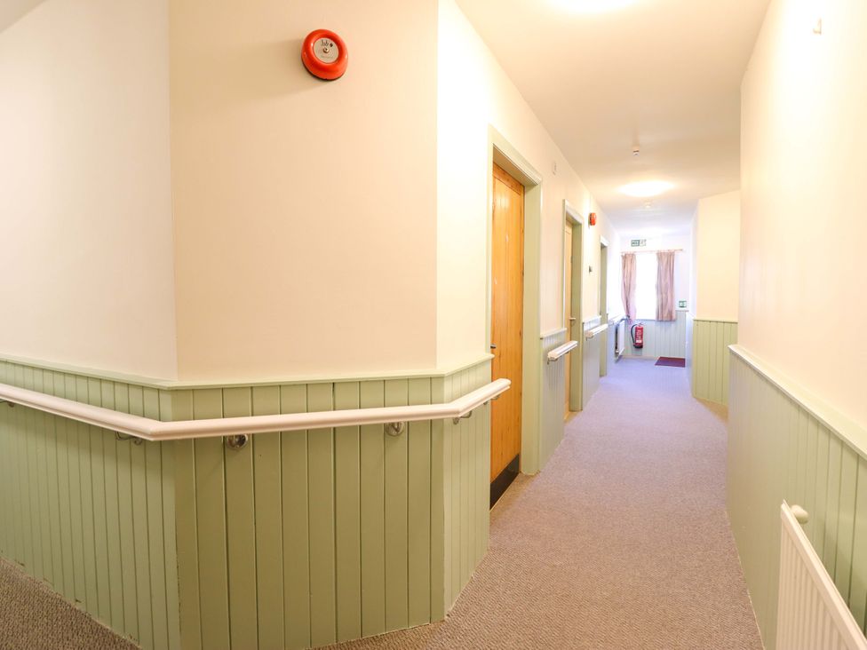 A corridor with doors and windows at Clwyd Special Riding Centre in Llanfynydd