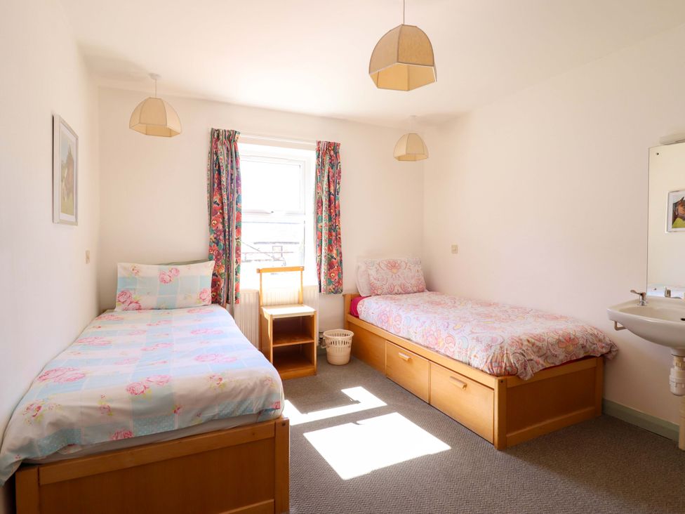 A bedroom with two beds and a sink at Clwyd Special Riding Centre in Llanfynydd