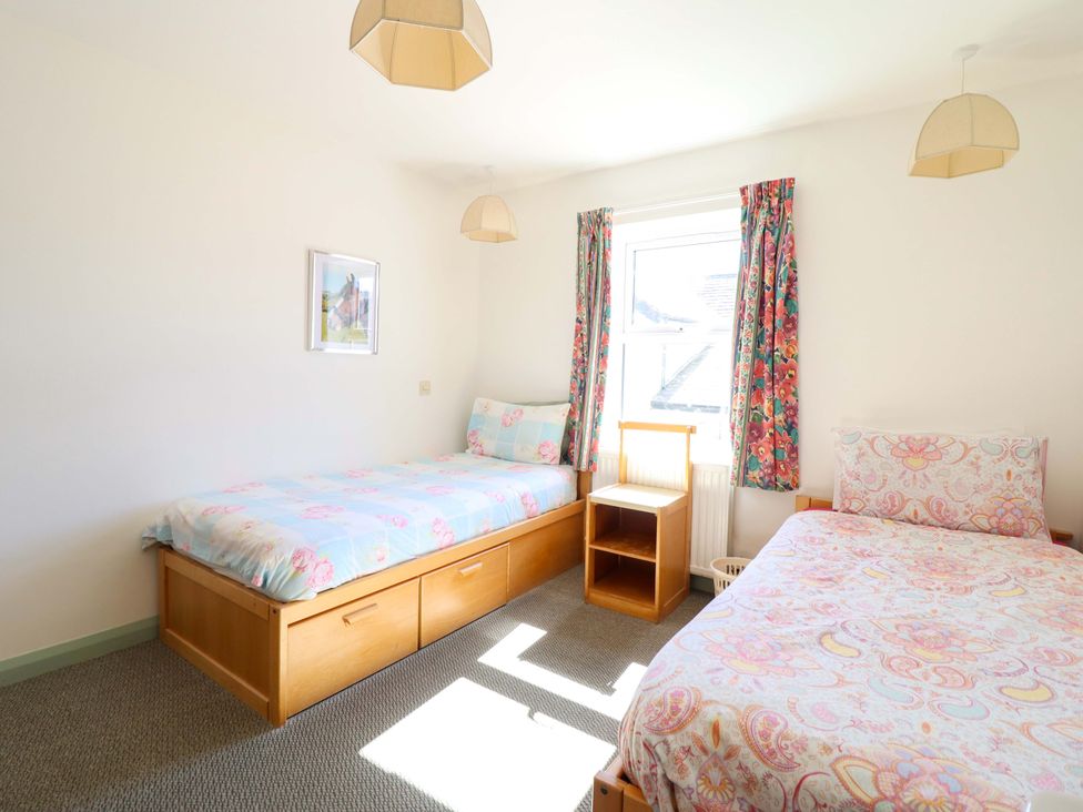A bedroom with two beds and a bookshelf at Clwyd Special Riding Centre Llanfynydd