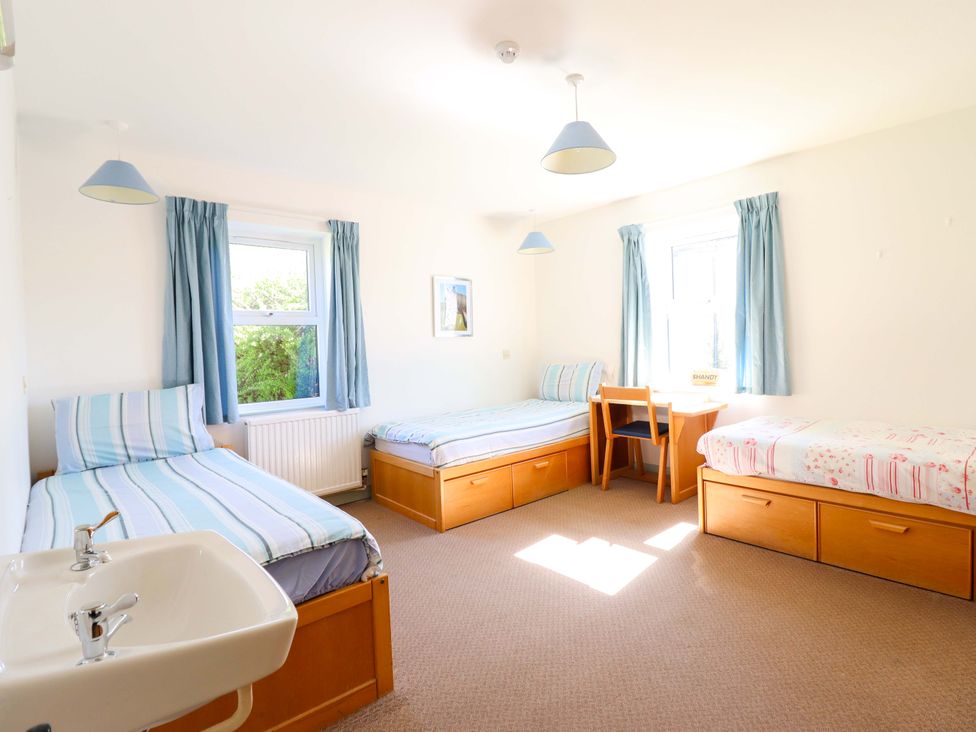 A bedroom with three beds and a table at Clwyd Special Riding Centre in Llanfynydd