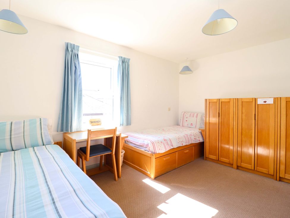 A bedroom with two beds and a chair at Clwyd Special Riding Centre in Llanfynydd