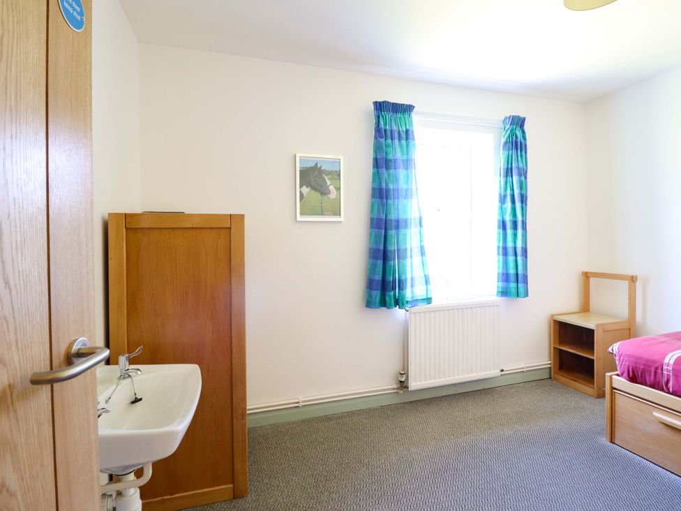 A bedroom with a bed and a sink at Clwyd Special Riding Centre Llanfynydd