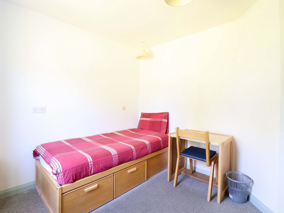A bedroom with a bed and desk at Clwyd Special Riding Centre, Llanfynydd