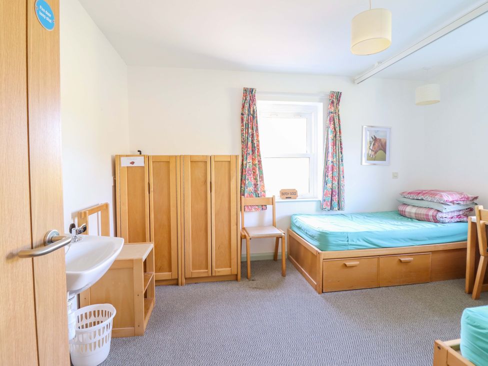 A bedroom with beds and storage furniture at Clwyd Special Riding Centre Llanfynydd